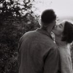 man and woman kissing in grayscale photography